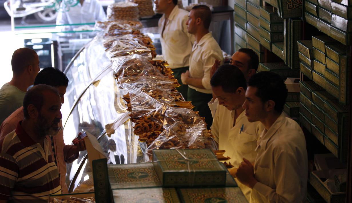 Warga Mesir membeli permen tradisional "Kahk" untuk perayaan Idul Fitri di toko roti, Kairo, (27/7/14). (REUTERS/Mohamed Abd El Ghany)