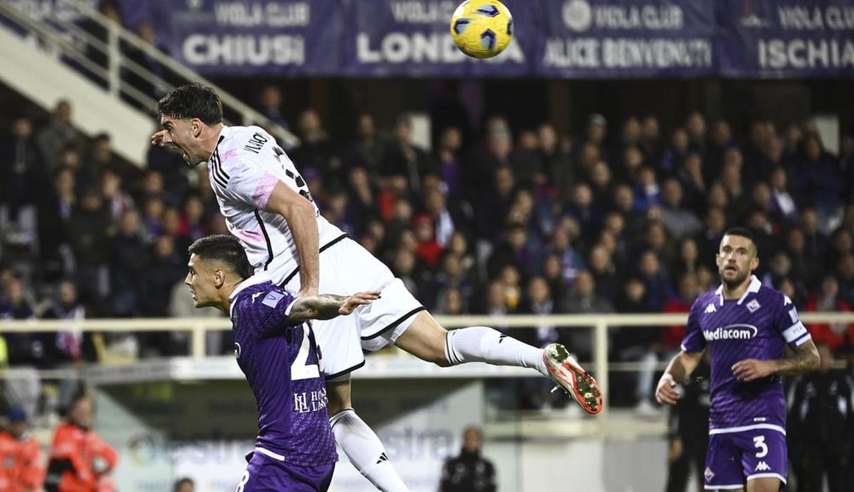 Pemain Juventus, Dusan Vlahovic, duel udara dengan pemain Fiorentina, Lucas Martinez, pada laga Liga Italia di Stadion Artemio Franchi, Senin (06/11/2023). (LaPresse via AP/Massimo Paolone)
