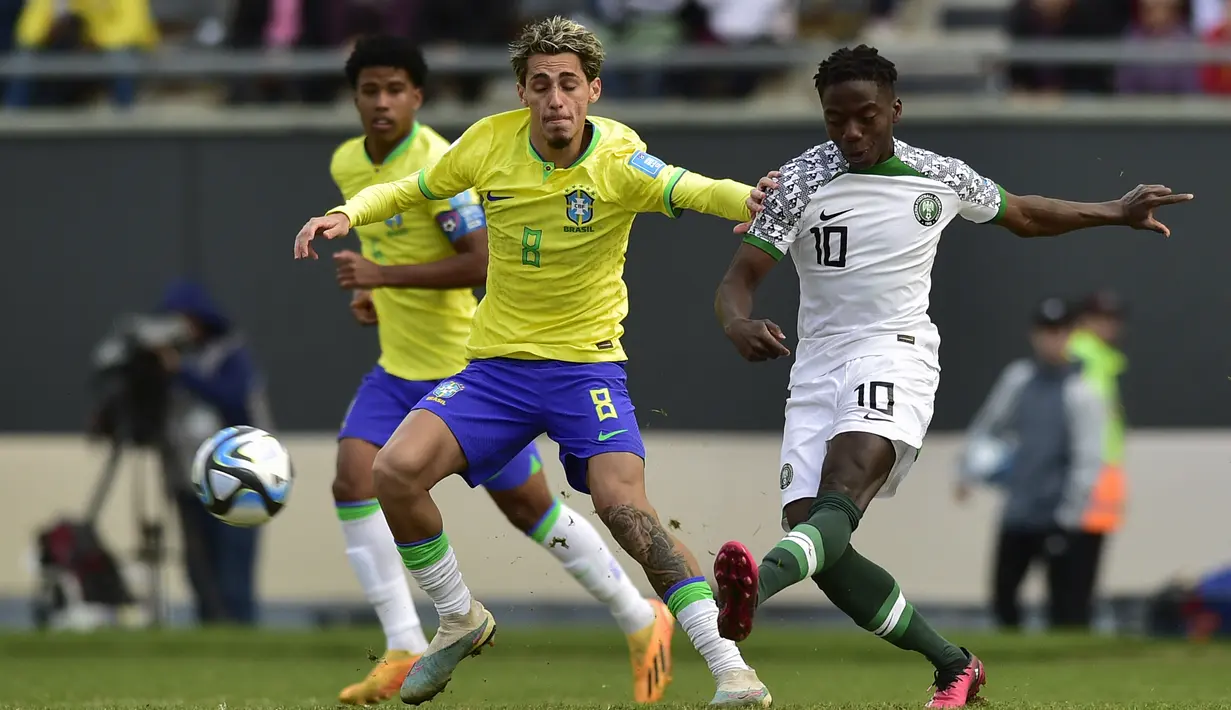 Gelandang Timnas Nigeria U-20, Victor Eletu (kanan) melepaskan tendangan di tengah kawalan gelandang Brasil U-20, Marlon Gomes pada laga terakhir Grup D Piala Dunia U-20 2023 di Unico Diego Maradona Stadium, La Plata, Argentina (27/5/2023). (AP Photo/Gustavo Garello)