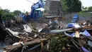 Petugas menggunakan alat berat menghancurkan bangunan yang terdampak proyek sodetan Ciliwung menuju Kanal Banjir Timur (KBT) di Kelurahan Cipinang Besar Selatan, Jakarta, Kamis (12/1/2023). Pemprov DKI mempercepat pembangunan sodetan kali Ciliwung menuju Kanal Banjir Timur (KBT) dengan tujuan mampu mengurangi dampak banjir dengan volume 60 kubik per detik. (merdeka.com/Imam Buhori)