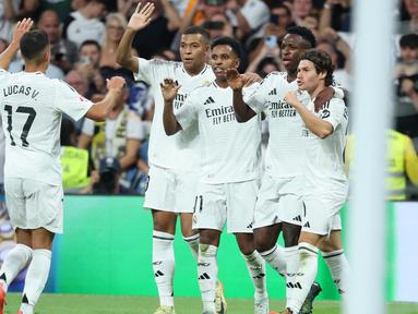 Pemain Real Madrid merayakan gol saat pertandingan sepak bola Liga Spanyol melawan RCD Espanyol di stadion Santiago Bernabeu, Madrid, pada 21 September 2024 atau Minggu (22/9/2024) dini hari WIB. (Thomas COEX/AFP)