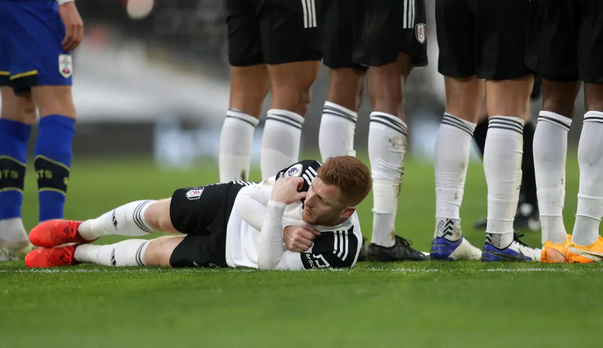 Gelandang Fulham, Harrison Reed berbaring di belakang rekan-rekannya yang membuat pagar hidup untuk menjaga tendangan bebas pemain Southampton dalam laga lanjutan Liga Inggris 2020/21 di Craven Cottage, Sabtu (26/12/2020). (AFP/Adam Davy/Pool)
