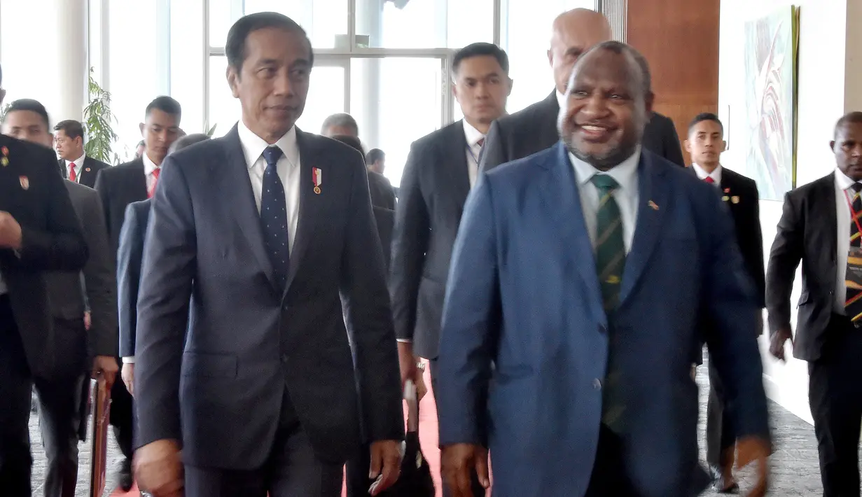 Kedatangan Jokowi di APEC Haus disambut tarian 'Hiri Moale'. Seusai penyambutan, PM Marape bersama Jokowi kemudian berjalan naik ke lantai dua APEC Haus untuk menuju ruang pelaksanaan tête-à-tête. (ANDREW KUTAN/AFP)