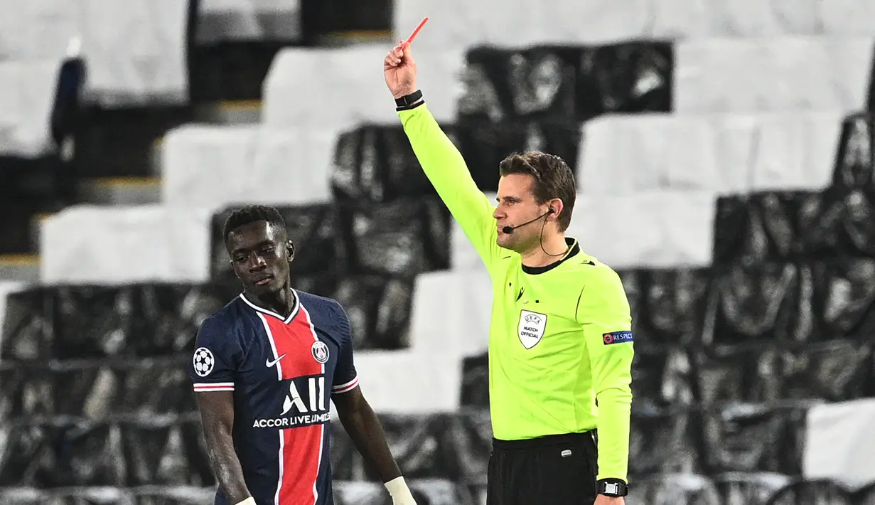 Gelandang Paris Saint-Germain, Idrissa Gueye menerima kartu merah dari wasit Felix Brych saat melawan Mancester City dalam laga leg pertama semifinal Liga Champions 2020/2021 di Parc des Princes Stadium, Paris, Rabu (28/4/2021). PSG kalah 1-2 dari Manchester City. (AFP/Anne-Christine Poujoulat)