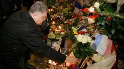 Presiden Ukraina Petro Poroshenko meletakkan bunga di salah satu lokasi serangan berdarah Paris di gedung konser Bataclan, Prancis, Minggu (30/11). (REUTERS/Gonzalo Fuentes)