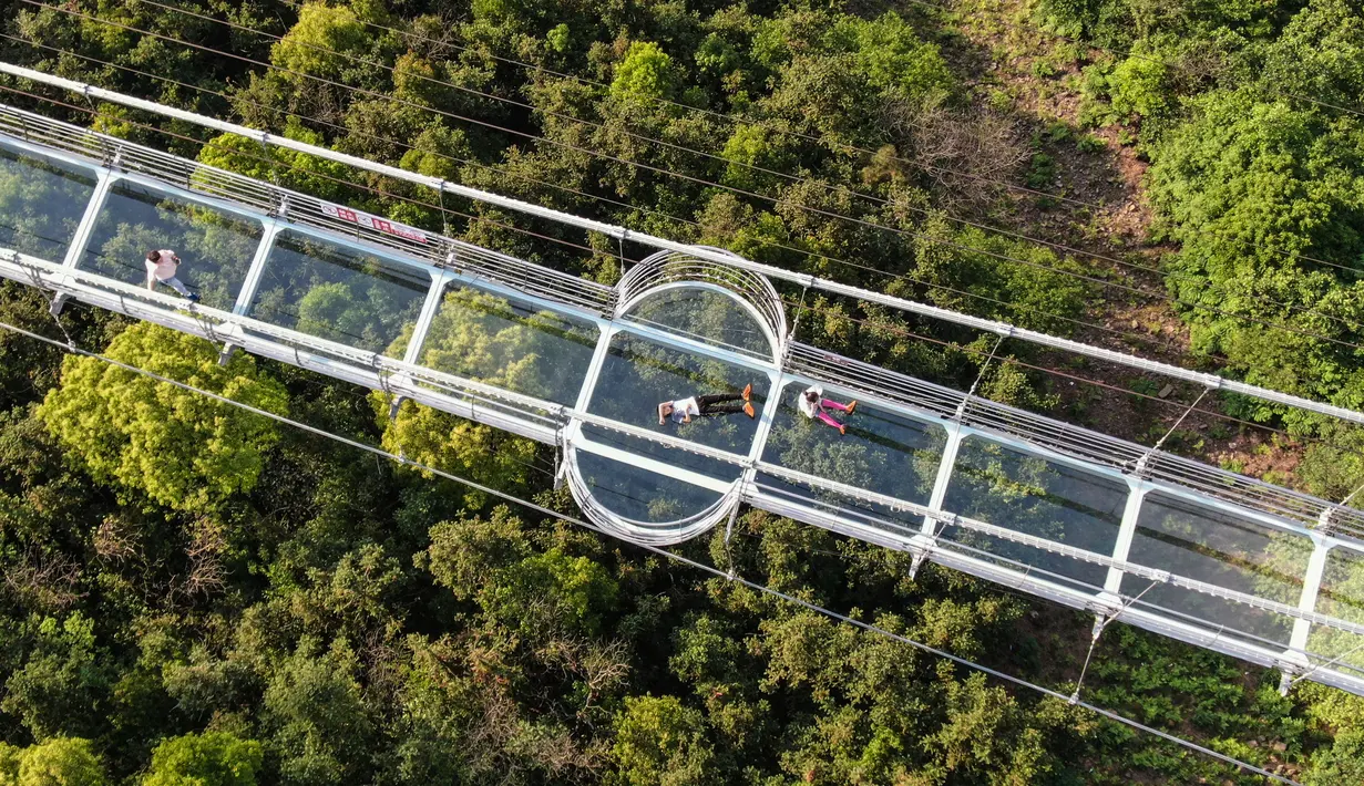 Foto yang diambil pada 4 Mei 2019 menunjukkan orang-orang mengunjungi jembatan berlantai kaca di Huaxi Adventure Park, Provinsi Jiangsu timur China. Jembatan kaca setinggi 518 meter ini menjadi tujuan wisata favorit di China. (Photo by STR / AFP)