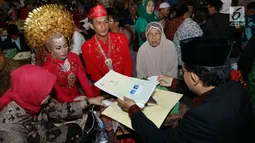 Sejumlah pasangan mengikuti nikah massal di malam pergantian tahun di Jalan MH Thamrin, Jakarta, Minggu (31/12). Sedikitnya 100 penghulu telah disiapkan Pemprov DKI Jakarta.  (Liputan6.com/Angga Yuniar)