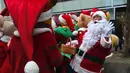 Santa Claus berpose selama acara mempromosikan musim Natal di sebuah distrik perbelanjaan di Seoul (13/11). Meski sebagian besar penduduknya adalah umat Budha, anak muda Korsel menikmati perayaan musim Natal tersebut. (AFP Photo/Jung Yeon-Je)