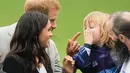Namun Pangeran Harry langsung memberiakan reaksi menggemaskan seakan memberi tahu bahwa ia tak boleh menepuk istrinya sembarangan. (Getty Images/Cosmopolitan)