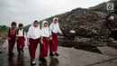 Sejumlah anak sekolah berjalan di samping tumpukan sampah di TPA Bantar Gebang, Kota Bekasi, Jawa Barat.  (Liputan6.com/Yoppy Renato)