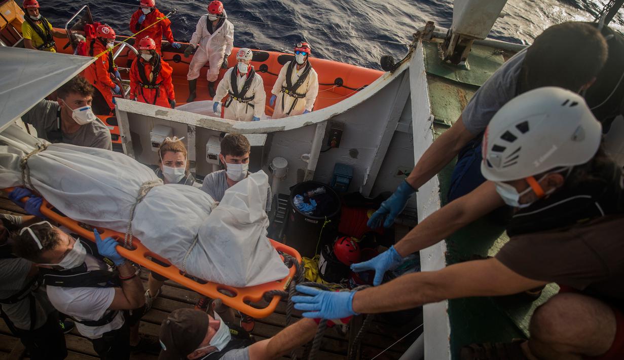 Petugas LSM Spanyol mengevakuasi jasad imigran Afrika sub-Sahara di tengah Laut Mediterania, lepas pantai Libya, Selasa (25/7). Dalam operasi penyelamatan, petugas menemukan 13 jasad di atas perahu karet yang membawa 160 orang migran. (AP/Santi Palacios)