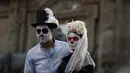 Peserta berkostum tengkorak menunggu dimulainya Prosesi Grand Catrinas, bagian dari Day of The Dead di Mexico City, Minggu (22/10). Puncak perayaan ditandai dengan kunjungan ke makam orang-orang yang dicintai pada 1 dan 2 November. (AP/Rebecca Blackwell)