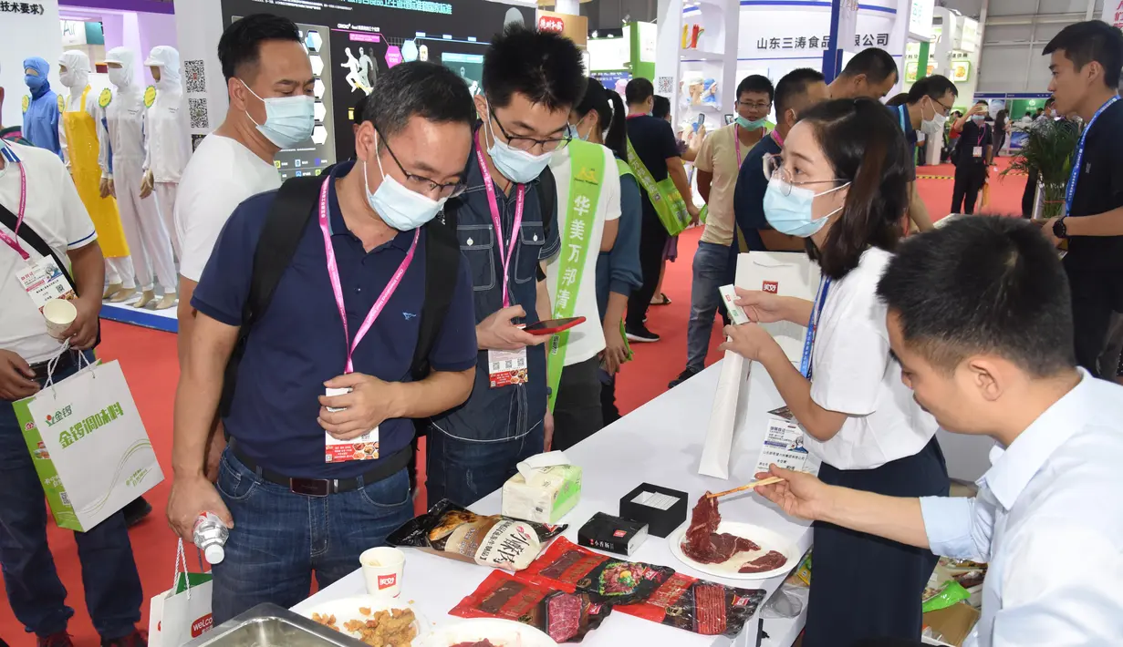 Para pengunjung melihat benda pameran dalam Pameran Industri Daging Internasional China ke-18 di Qingdao, Provinsi Shandong, China, 10 September 2020. (Xinhua/Li Ziheng)