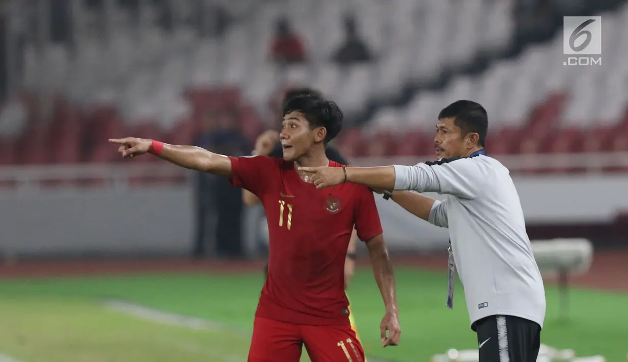 Bek timnas Indonesia -19, Firza Andika (kiri) menerima arahan pelatih Indra Sjafri saat melawan Uni Emirat Arab U-19 pada penyisihan Grup A Piala AFC U-19 2018 di Stadion GBK, Jakarta, Rabu (24/10). Indonesia unggul 1-0. (Liputan6.com/Helmi Fithriansyah)