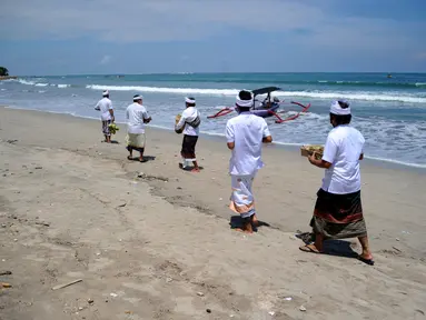 Umat Hindu menghadiri upacara Melasti menjelang Hari Raya Nyepi Tahun Baru Saka 1943 di Pantai Kuta, Bali (11/3/2021). Ritual Melasti untuk menyucikan alam agar Hari Raya Nyepi dapat berjalan  hening serta damai.(AFP/Sonny Tumbelaka)