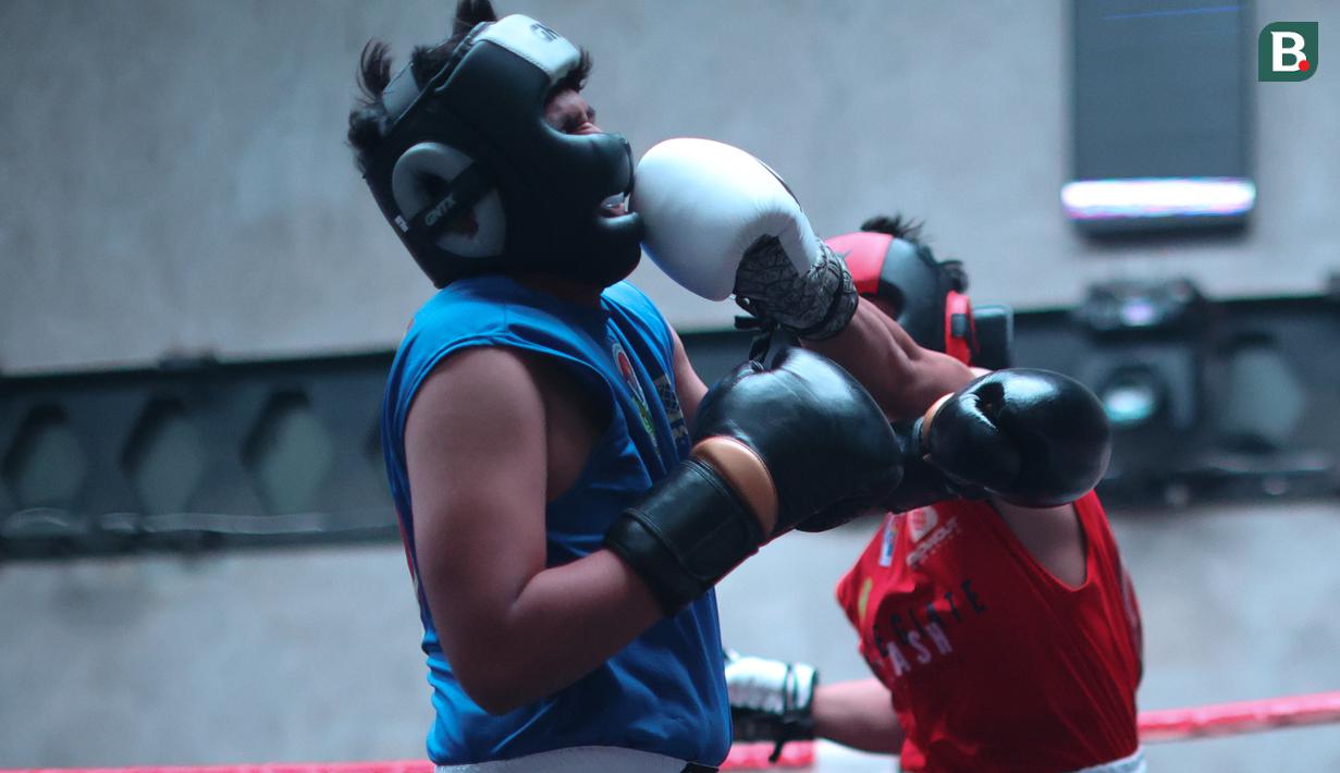 Pukulan Gaga Muhammad (kanan) mengenai wajah Raja 'Big Heca' yang bertanding pada ajang bertajuk University Boxing League (UBL) yang berlangsung di Embassy Lounge Jakarta, Senayan, Jumat (20/9/2024) malam WIB. (Bola.com/Abdul Aziz)