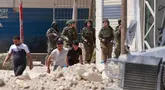 Tentara Israel berjaga-jaga ketika warga Palestina meninggalkan rumah-rumah mereka yang dijadwalkan akan dihancurkan di kamp pengungsi Tulkarem pada 26 Mei 2025. (Jaafar ASHTIYEH/AFP)