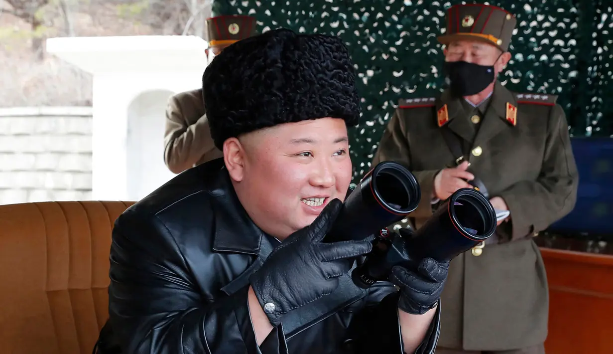 Pemimpin Korea Utara Kim Jong-un tampak tersenyum saat memantau latihan militer Korea Utara di lokasi yang dirahasiakan pada hari Senin (2/3/2020). Latihan militer digelar setelah Korea Utara mengancam akan menunjukkan senjata baru. (Korean Central News Agency/Korea News Service via AP)