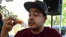 Mario Monez, salah satu peserta lomba saat menyelesaikan makan 60 cabai Habanero dalam Habanero Eating Contest di Restoran Chichen Itza, Los Angeles, Minggu (21/6). (AFP PHOTO/Mark RALSTON)