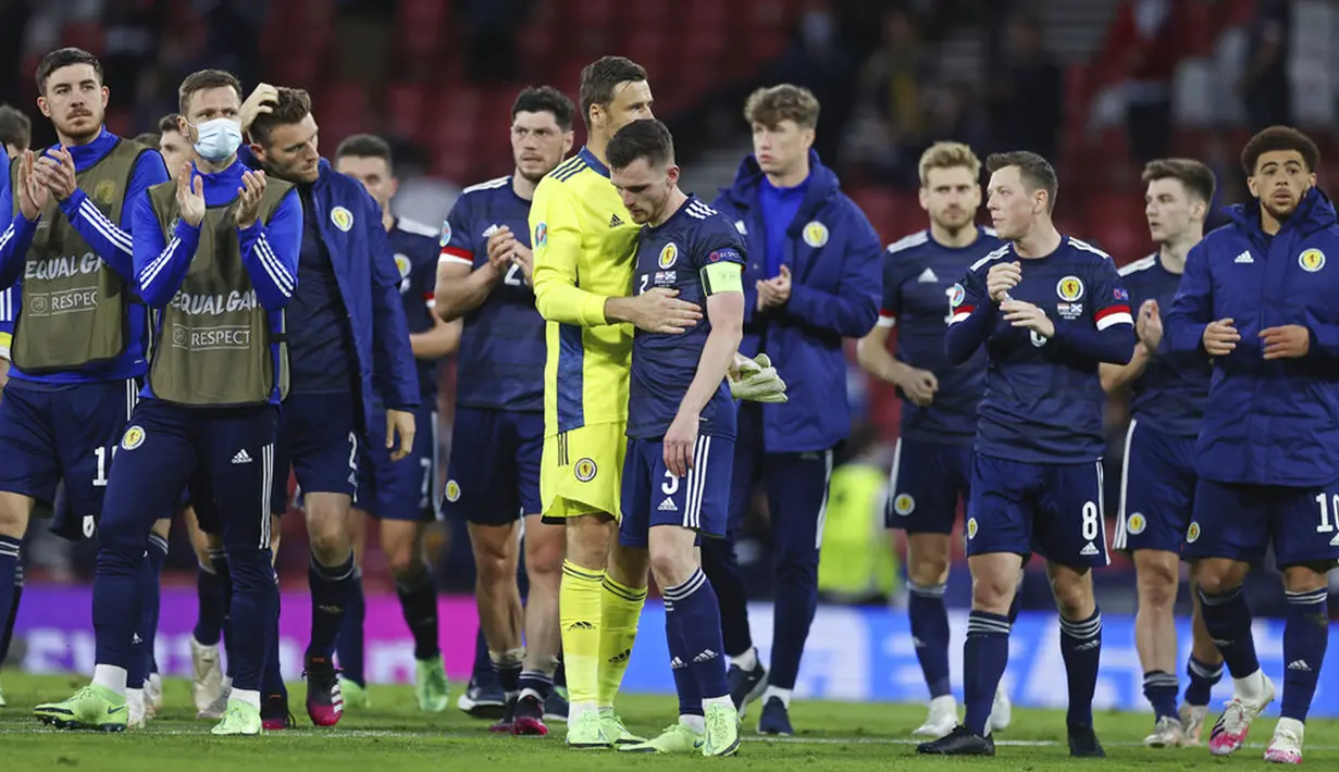 Kapten Skotlandia Andrew Robertson (tengah) dihibur oleh kiper David Marshall pada akhir laga melawan Kroasia pada pertandingan Grup D Euro 2020 di Stadion Hampden Park, Glasgow, Selasa (22/6/2021). Kroasia menang 3-1. (Lee Smith, Pool Photo via AP)