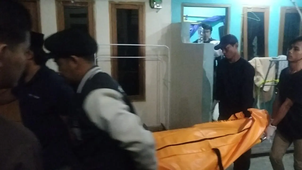 Anggota kepolisian saat membawa jenazah korban yang ditemukan tewas di dalam sebuah kontrakan di Bojongsari, Depok.