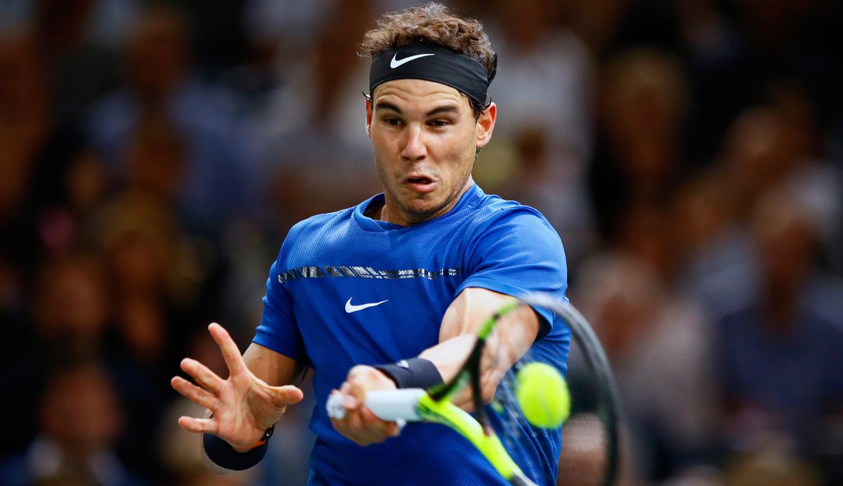 Petenis Spanyol, Rafael Nadal mengembalikan bola ke arah petenis Korsel, Hyeon Chung pada babak kedua Paris Masters di Paris, Rabu (1/11). Usai mengalahkan Hyeon Chung, Nadal sukses mengunci peringkat satu dunia hingga akhir tahun 2017. (AP/Francois Mori)