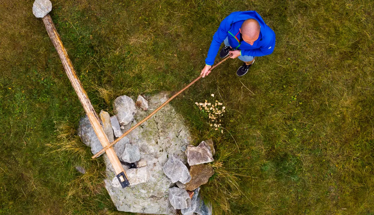Seorang pria memukul tulang kaki sapi saat bermain 'Gilihuesine' di pegunungan Bettmeralp, Swiss (16/9). Permainan tradisional Gilihuesine diikuti oleh enam pemain dimana pemain dapat mendapatkan tulang saat dipukul. (Valentin Flauraud/Keystone via AP)