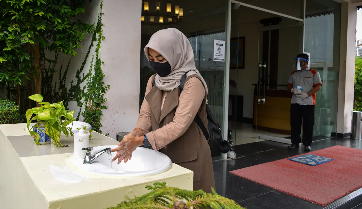 Seorang tamu mencuci tangannya sebelum memasuki sebuah hotel yang dibuka kembali setelah ditutup selama tiga bulan akibat pandemi COVID-19 di Banda Aceh pada Rabu (15/7/2020). (Photo by CHAIDEER MAHYUDDIN / AFP)