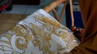 Perajin batik sedang membatik dengan teknik tulis pada Minggu (21/2/2021) di Kawasan Sentra Batik Laweyan Solo. (Liputan6.com/Laudia Tysara)