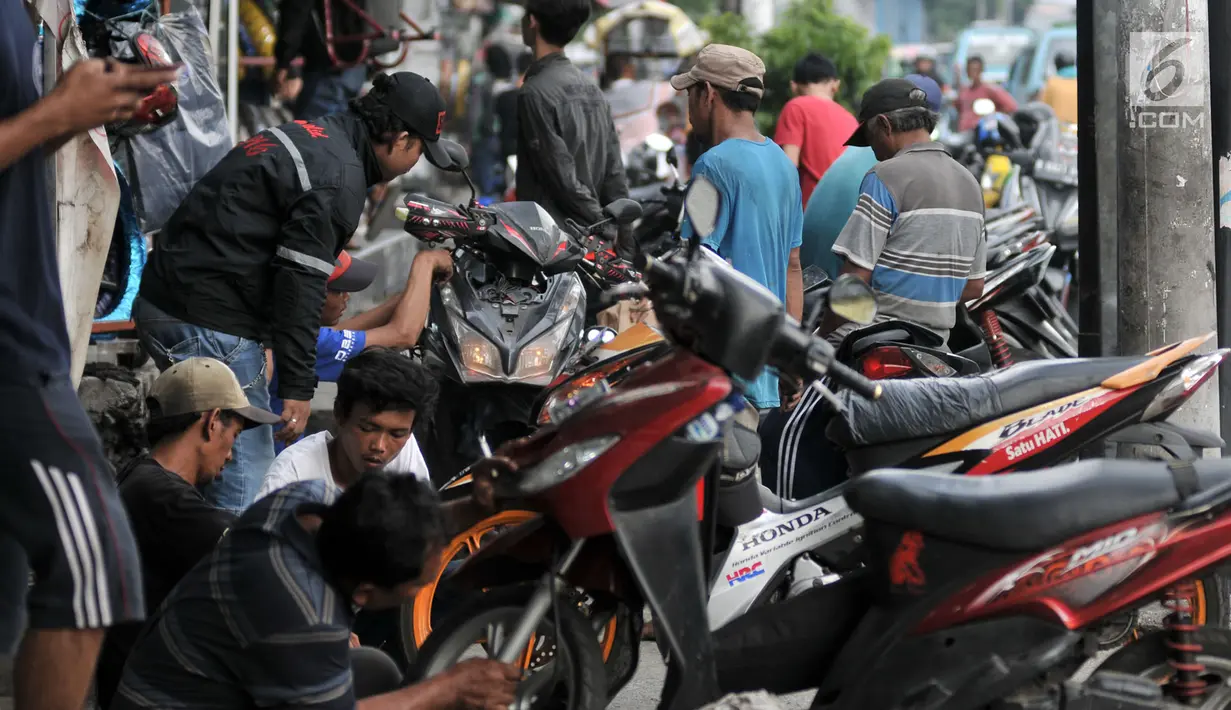 Montir memperbaiki motor di bengkel di Jalan Otista, Jakarta, Minggu (26/5/2019). Jelang Idul Fitri atau Lebaran, jumlah pelanggan bengkel motor di kawasan Otista meningkat, mulai dari menyervis mesin hingga membeli perlengkapan guna kesiapan mudik mendatang. (merdeka.com/Iqbal S. Nugroho)