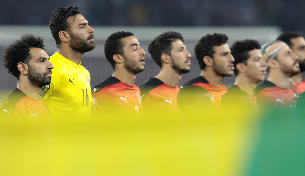 Striker Mesir, Mohamed Salah (kiri) dan rekan setim berbaris mendengarkan lagu Kebangsaan Mesir menjelang dimulainya laga final Piala Afrika 2021 menghadapi Senegal di Stade d'Olembe, Yaounde, Kamerun (6/2/2022). (AFP/Kenzo Tribouillard)