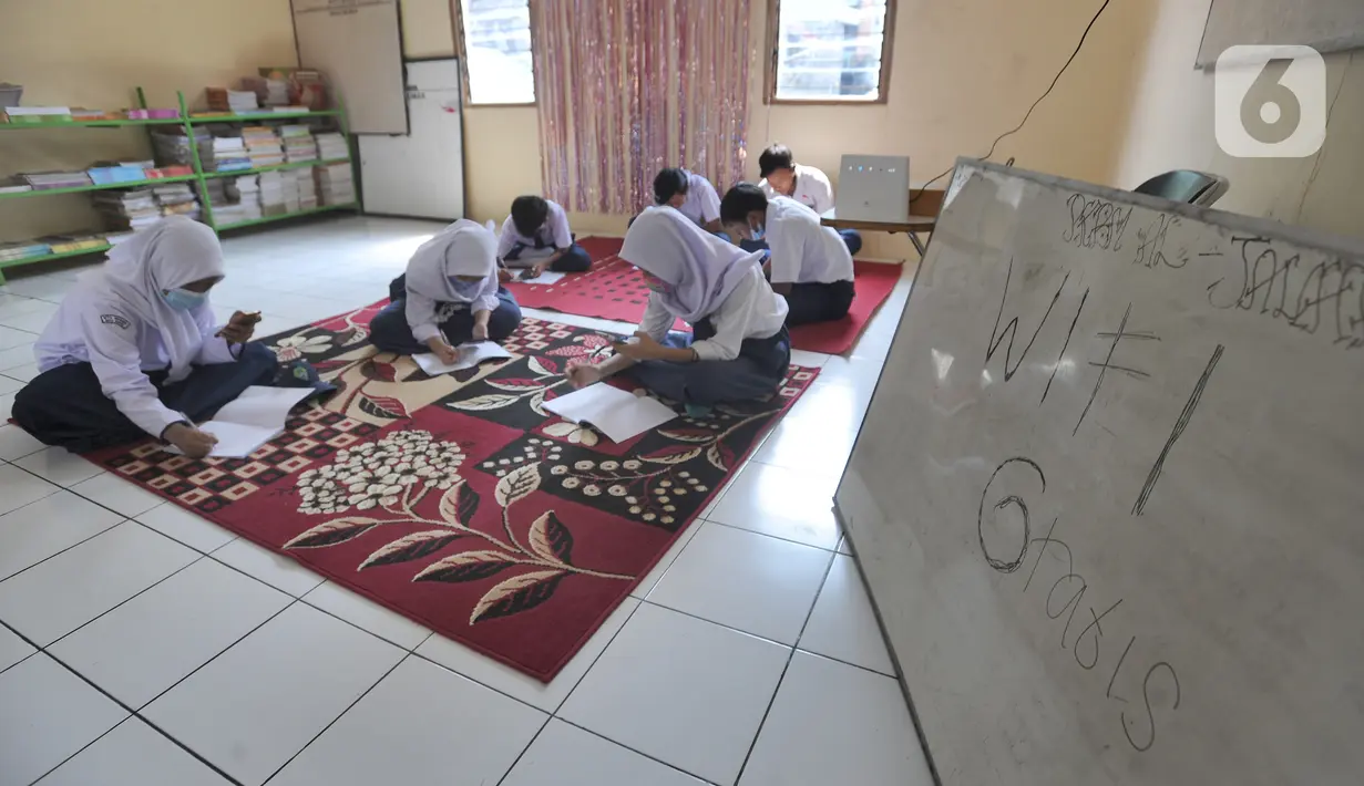 Murid-murid SMP belajar dengan memanfaatkan wifi gratis di Balai RW kawasan Tegal Gundil, Bogor, Jawa Barat, Senin (21/9/2020). Pemkot Bogor menyebar lebih dari 50 titik wifi publik gratis untuk menunjang Pembelajaran Jarak Jauh (PJJ) siswa di Kota Bogor. (merdeka.com/Arie Basuki)