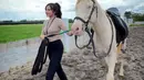 Dalam momen lain, wanita yang menjadi model video klip lagu 'Los Dol' dan 'Kalih Welasku' milik Denny Caknan itu tampil penuh pesona. Ia terlihat melenggang penuh percaya diri sambil membawa kuda yang ditungganginya. Penampilan Bella Bonita dengan body goals-nya ini juga bikin salfok netizen. (Liputan6.com/IG/@bellabonita_r.a)
