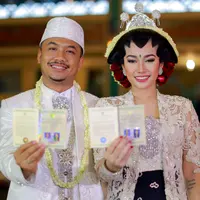 Ratu Felisha dan Arie Pujianto memamerkan buku nikah setelah  prosesi akad nikah dinyatakan sah. (Adrian Putra/Bintang.com)