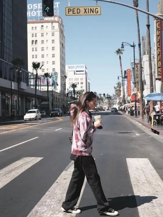 Kali ini, Enzy tampil dengan gaya sporty. Enzy memadukan tie-dye top dengan black pants. (Instagram/enzystoria).