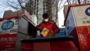 Kurir bersiap untuk melakukan pengiriman paket di pusat distribusi di Beijing, China, Selasa (18/2/2020). Hingga 19 Februari 2020, tercatat 2.118 orang meninggal dunia akibat virus corona atau COVID-19 di China. (AP Photo/Ng Han Guan)