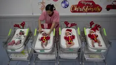 Perawat merapikan pakaian bayi yang baru lahir di Rumah Sakit Synphaet, Bangkok, Thailand, Selasa (24/12/2019). Bayi-bayi tersebut dipakaikan kostum sinterklas untuk menyambut Hari Raya Natal. (AP Photo/Sakchai Lalit)
