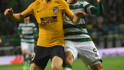 Bek Atletico Madrid, Juanfran berebut bola dengan pemain Sporting CP, Marcos Acuna pada leg kedua perempat final Liga Europa di Estadio Jose Avalade, Jumat (13/4). Atletico Madrid tetap maju ke semifinal meski kalah 0-1. (FRANCISCO LEONG / AFP)