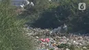 Seorang pria terlihat di antara sampah yang menumpuk di aliran kali Kampung Bogor, Desa Setiasih, Tarumajaya, Kabupaten Bekasi, Rabu (30/9/2020). Tumpukan sampah itu akibat kurangnya kesadaran masyarakat untuk tidak membuang sampah sembarangan khususnya di aliran kali. (Liputan6.com/Herman Zakharia)