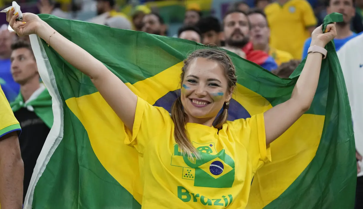 Suporter wanita Brasil tersenyum saat menghadiri pertandingan melawan Serbia pada laga Piala Dunia di Stadion Lusail, Qatar, Kamis (24/11/2022). (AP/Aijaz Rahi)