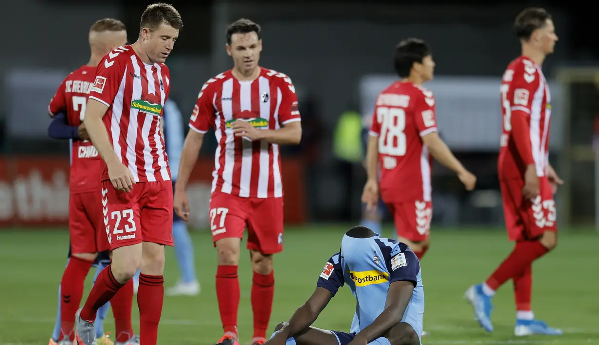 Striker Borussia Monchengladbach, Marcus Thuram, terduduk usai timnya dikalahkan SC Freiburg pada laga lanjutan Bundesliga di Freiburg, Jumat (5/6/2020) waktu setempat. Monchengladbach kalah 0-1 atas Freiburg. (AFP/Ronald Wittek/Pool)