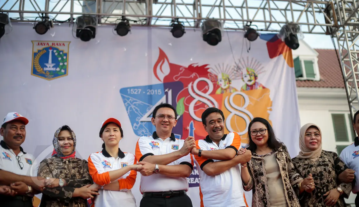 Gubernur DKI, Basuki Tjahaja Purnama dan Wagub Djarot Saiful Hidayat bergandeng tangan seusai membuka perayaan HUT Jakarta yang ke-488, di Taman Fatahillah, Jakarta, Minggu (31/5/2015). (Liputan6.com/Faizal Fanani)