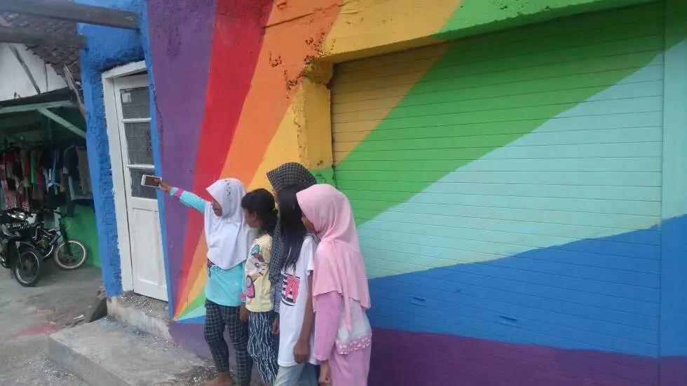 Pengunjung kampung pelangi memanfaatkan libur lebaran berfoto-foto. (foto : Liputan6.com/edhie prayitno ige)