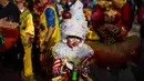 Seorang anak yang mengenakan pakaian badut ikut serta dalam parade badut tahunan di Sesimbra, Portugal pada Senin (4/3/2019). Tidak hanya orang dewasa anak-anak pun ikut merias diri menjadi badut. (PATRICIA DE MELO MOREIRA / AFP)