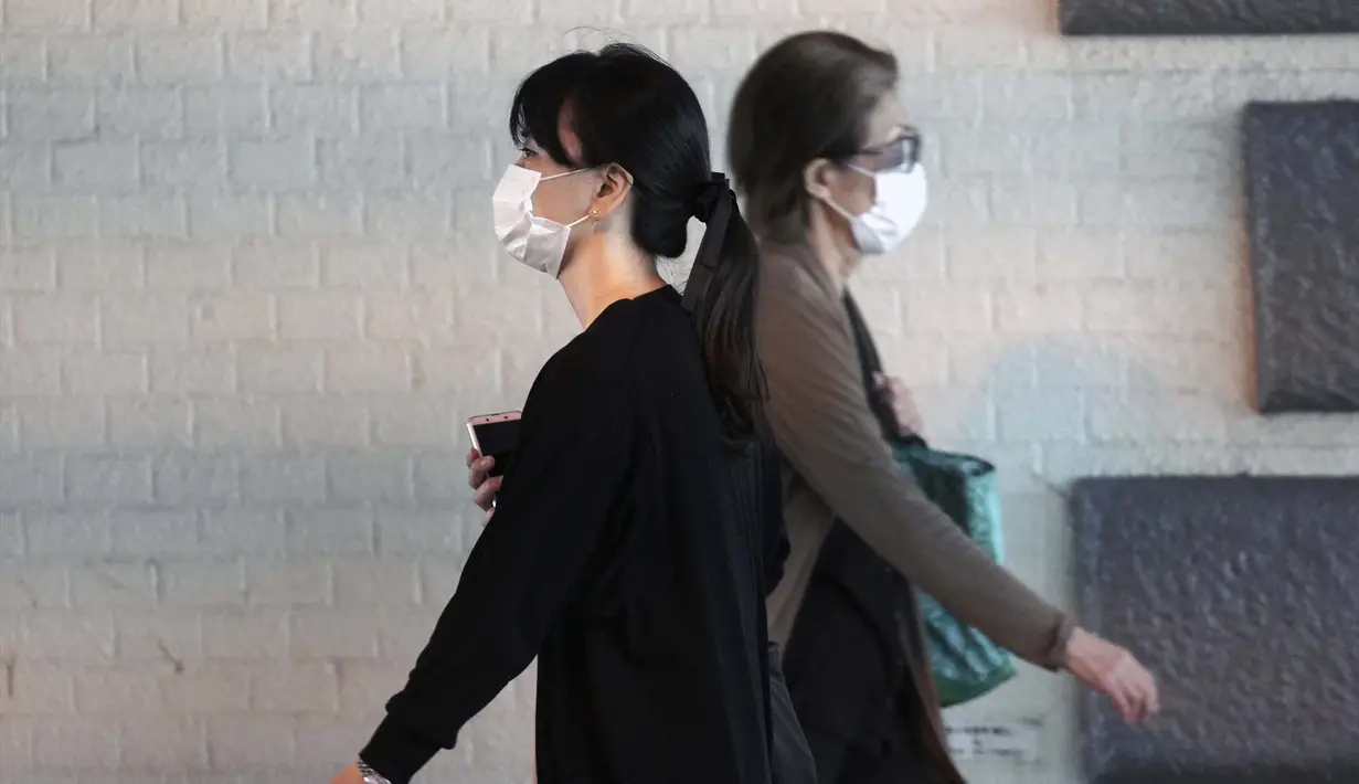 Wanita yang mengenakan masker pelindung untuk membantu mengekang penyebaran virus corona COVID-19 berjalan di Tokyo, Jepang, Jumat (16/10/2020). Tokyo mengonfirmasi lebih dari 180 kasus virus corona COVID-19 baru pada hari Jumat. (AP Photo/Eugene Hoshiko)