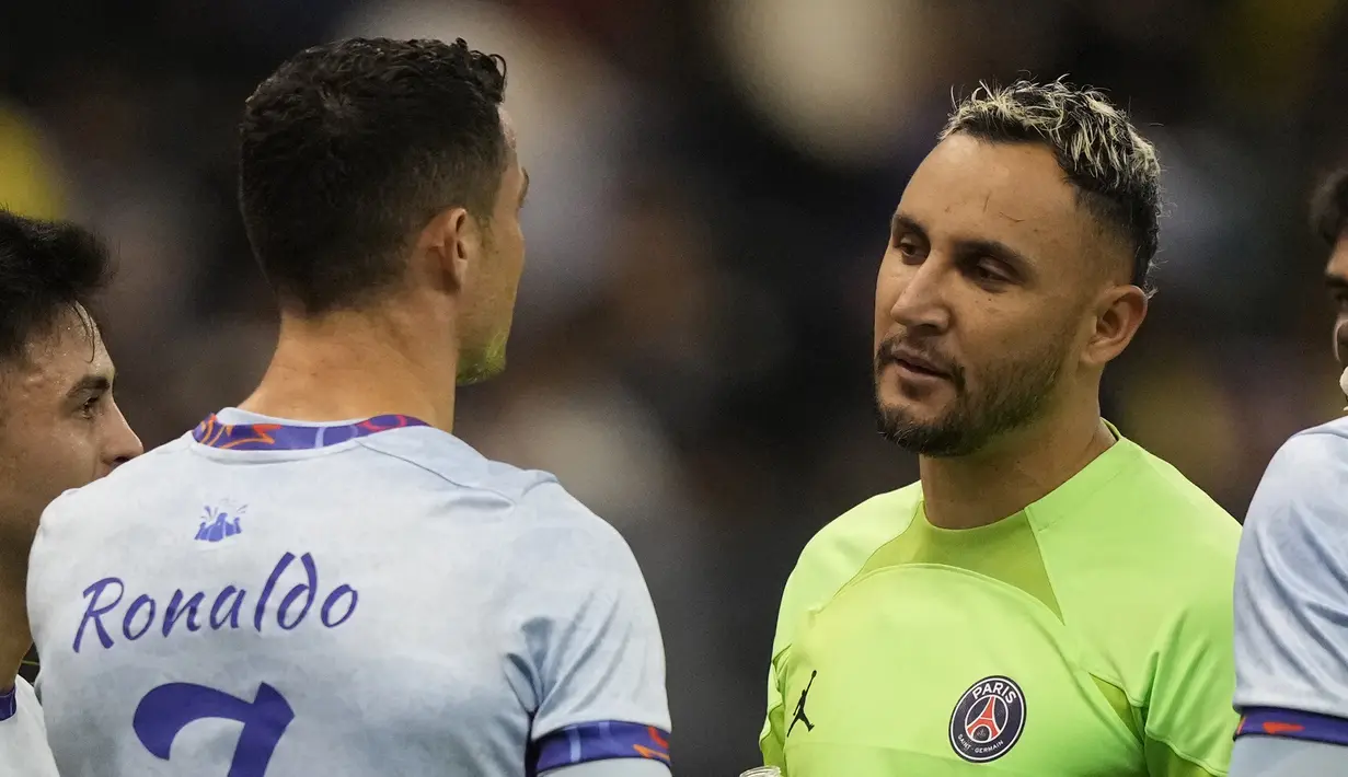Penjaga gawang PSG, Keylor Navas (kanan) berbincang dengan Cristiano Ronaldo setelah laga Riyadh Season Cup antara Riyadh All-Star melawan PSG yang berlangsung di King Fahd Stadium, Riyadh, Jumat (20/1/2023) dini hari WIB. Keylor Navas dan Ronaldo juga sama-sama pernah membela Real Madrid dalam waktu yang lama. (AP Photo/Hussein Malla)