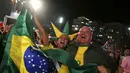 Di pantai Copacabana, Rio de Janeiro, (23/6/2014), warga Brasil bersorak merayakan keberhasilan tim Samba lolos ke fase knock out Piala Dunia 2014. (REUTERS/Pilar Olivares) 