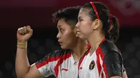 Reaksi ganda putri Indonesia Apriyani Rahayu (kanan) dan Greysia Polii usai menang atas pasangan nomor satu dunia asal Jepang Yuki Fukushima dan Sayaka Hirota pada penyisihan Grup A cabang bulu tangkis Olimpiade Tokyo 2020 di Musashino Forest Sports Plaza, Selasa (27/7/2021). (Alexander NEMENOV/AFP)