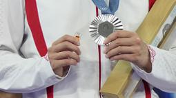 Pebulu tangkis tunggal putri China, He Bing Jiao memegang pin bergambar bendera Spanyol dan medali perak Olimpiade Paris 2024 setelah laga final yang berlangsung di Porte de la Chapelle Arena, Paris, Prancis, Senin (05/08/2024). (AP Photo/Kin Cheung)