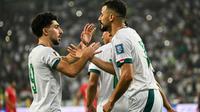 Penyerang Irak bernomor punggung 18, Aymen Hussein, merayakan gol pertamanya bersama rekan satu timnya dalam pertandingan kualifikasi Piala Dunia FIFA 2026 antara Irak dan Palestina di Stadion Internasional Basra, Basra, pada 10 Oktober 2024. (Hussein FALEH/AFP)